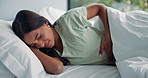 Stomach ache, illness and cramps with woman in bedroom for menstruation pain, endometriosis or pms. Period cycle, indigestion or food poisoning with person at home for appendicitis, ibs or discomfort