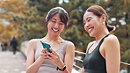 Fitness, funny and woman with Japanese women outdoor together for health, sports or wellness tracking. Exercise, laughing and social media with athlete friends tracking training or workout progress