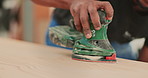 Hands, carpenter and sander for wood in workshop for texture, construction or design at startup. Person, tools or machine for board, finish and creative at factory for furniture production at company