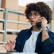 Man, phone call and logistics with boxes, computer and negotiation for ...