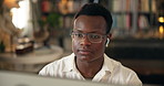 Black man, computer and reading in home office for remote work, article research and resources for news. Journalist, glasses and typing at tech for creative writing, review or online story with music