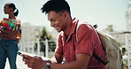 Happy, university student and man with phone in city for travel to school, campus and college. Learner, education and person on smartphone for social media, online chat and internet on break outdoors