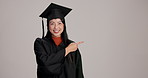 Pointing, mockup and face of woman with graduation in studio for option, decision or choice with list. Happy, portrait and Japanese student with menu for academic achievement by gray background.