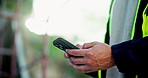 Construction worker, hands and phone outdoor with social media, texting and break from builder job. Engineer, mobile networking and protection vest for safety on project site with contractor