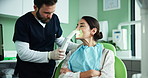 Dentist, man and woman with light for teeth whitening with flash, cleaning or oral wellness at clinic. People, patient and medic with LED equipment for mouth, smile and hygiene services at hospital