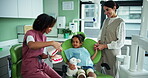 Dentist, tooth model and brushing advice with girl, woman and appointment for checkup. Child healthcare, explanation or consulting with kid for dental care, oral hygiene or cleaning service in clinic