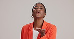 Woman, blowing kiss and face with romance, love and emoji gesture with smile in studio. Valentine, happy and black female model with care, date and silly with loving hand sign and brown background