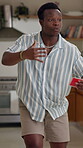 Acting, man and playing game in home with description, answer clues or explaining with gestures. Entertainment, black person or card for challenge, urgency or guess activity for competition in lounge