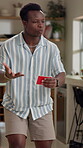 Mime, man and playing game in home with description, answer clues and explaining with gestures. Entertainment, black person and card for challenge, acting and guess activity for competition in lounge