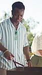 Man, bbq and grill at party with charcoal, tongs or prepare for cooking in summer at social event in backyard. Person, food and fire for barbecue, heat and ready for new year celebration with friends