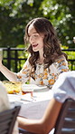 Friends, praying and woman in backyard with food for celebration, new years event or lunch. Holding hands, party and eating with people in home for grace, thanks and gratitude for bbq meal together