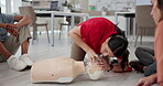 First aid, learning and mannequin with people in cpr workshop for training, healthcare and demonstration. Paramedic course, instructor and teaching with person in class for emergency and rescue