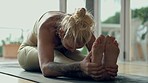 Stretching, yoga and woman for fitness, exercise or holistic wellness on floor in home or studio. Balance, muscle health and focus of young person in pilates, training and meditation in peace or calm