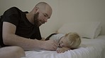 Drawing, learning and a father and child in a family home for creativity and art. Man or dad and kid or son together on a bed to draw on paper for bonding, development and quality time in a house