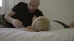 Drawing, child and father together in a family home bedroom for creativity, art and learning. Man and kid or son on a bed to draw with crayon colors and paper for bonding and development in a house