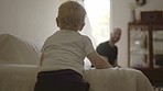 Father, child and playing on a sofa in a family home with love, care and fun for development. Man or dad and kid or son together on a couch to play for bonding, development or quality time in a house