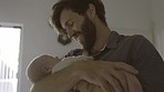 Father with baby, love and family bonding for relationship, hug and cuddle child at home. Man rock newborn to sleep, new dad and affection with care in living room