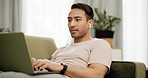 Man, laptop and typing or music on sofa as freelance work for online communication, project or planning. Asian person, cellphone or audio listening on couch in home internet, social media chat as job