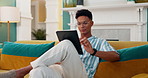 Smile, relax and tablet with man on sofa for online reading, communication and social media post. Networking update, contact and streaming with person in living room at home for app and scroll