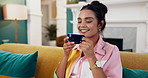 Happy woman, coffee and cup with laptop on sofa for morning beverage, drink or relaxing at home. Calm, female person or user with smile in joy for caffeine, comfort or warmth on computer at house