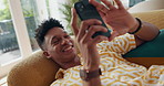 Happy man, phone and smile to relax on social media for rest or comfort on weekend in home on sofa. Chilling, technology and male person with mobile on couch for calm peace and online dating on app