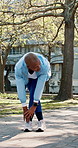 Senior, woman and stretching with friends for fitness, workout preparation or warm up exercise at park. Mature, female person or getting ready with training partner for outdoor health and wellness