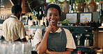 Smile, barista and face of black woman in coffee shop at counter for hospitality or customer service career. Confident, portrait and female cafe business owner from Kenya with pride for restaurant.