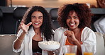 Popcorn, laughing and friends with television in home for relax, entertainment or bonding on weekend. Movie, snack and women watching comedy film with juice on sofa in living room at apartment.