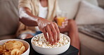 Relax, couch and hands of person with popcorn for watching tv show, streaming or subscription service in home. Eating, snacks and man on sofa for movies, television or weekend chill in living room