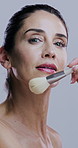 Beauty, brushes and face of mature woman in studio on gray background for wellness, skincare and makeup. Cosmetology, application and portrait of person with tools for cosmetics, powder and products