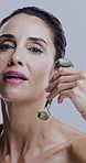 Face, funny and jade roller with mature woman in studio for morning cosmetics or skincare routine. Laughing, massage and wrinkles with person on white background for dermatology or natural beauty