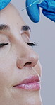 Beauty, woman and injection with forehead filler for wrinkle reduction, facelift or hyaluronic acid. Surgeon hands, gloves and collagen implant procedure for anti aging or change on studio background