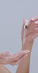 Beauty skincare, woman and hands with serum for skin hydration, anti aging treatment or wrinkles reduction. Mature person, portrait or cosmetics product application for self care on studio background