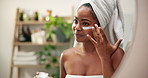 Woman, smile and apply lotion in bathroom for sunscreen, hydration benefits and skincare routine. Person, mirror reflection and cream with collagen for facial treatment, dermatology wellness at house