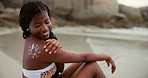 Beach, smile and woman with sunscreen for skincare, uv protection and body care for beauty. Ocean, sun cream and African girl with spf cosmetics for health, dermatology and travel on holiday to relax