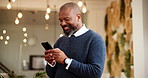 Mature, black man and typing with phone at hotel for communication, conversation or checkin notification. Happy, male person or tourist with smile on mobile smartphone for online accomodation or app