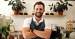 Arms crossed, face and smile with man in coffee shop as manager or owner of small business. Happy, hospitality and welcome with friendly barista or waiter in apron for cafe and restaurant management
