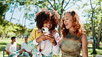 Phone, nature and girl friends in conversation for celebrity gossip with online blog. Laughing, social networking and young women with cellphone browsing media online for funny post outdoor in park.