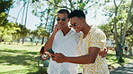Phone, nature and friends in conversation laughing for celebrity gossip with online blog. Happy, social networking and young men with cellphone browsing media online for funny post outdoor in park.