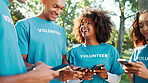 Phone, volunteer and group of friends in park for charity event, community service and teamwork. Volunteering, NGO and men with women on smartphone for social media, internet and online coordination