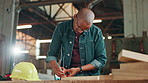 African man, carpenter and measuring tape for wood, drawing or design process at workshop. Person, tools and pencil with plank, paper and creative for furniture, manufacturing or industry in factory