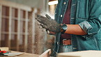 Dust, carpenter and hands of person in workshop for construction worker, woodwork and furniture. Handyman, renovation and manufacturing with closeup of contractor for  lumber, warehouse and builder