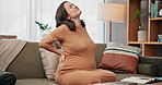 Pregnant woman, back pain and injury with discomfort on sofa for bad posture, pressure or strain at home. Female person, baby belly or pregnancy with ache or sore spine for muscle tension at house