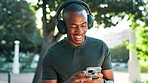Black man, fitness and phone with headphones for music, listening or radio podcast in nature. Active, male person or runner with earphones or mobile smartphone for audio, playlist or sound at park