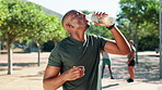 Happy man, fitness and drinking with water bottle at park for hydration, break or rest in nature. Active, thirsty or male person with mineral liquid for workout, exercise or natural sustainability