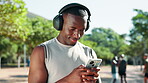 Phone, black man and runner in park for exercise, wellness and fitness. Radio, podcast and African athlete with training music, headphones and health workout for cardio and jog outdoors in nature