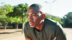 Tired, break and black man with fitness in nature for sports, exercise and training for marathon. African athlete, breathe and exhausted from workout with sweat, run fatigue and cardio in park