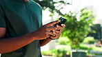 Man, hands and typing with phone for fitness, sport app or browsing social media at outdoor park. Closeup, male person or texting with mobile smartphone for tracking performance or music playlist