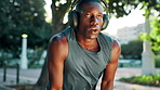 Outdoor, tired and man with headphones, fitness and playlist for workout in morning, sweating or runner. Breathing, break and black person with fatigue, exhausted or checking smart watch for progress