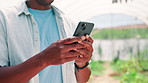 Person, hands and farmer with phone in greenhouse for online research, agro business or tips on farm. Closeup, environmentalist or texting with mobile smartphone for communication or conservation app